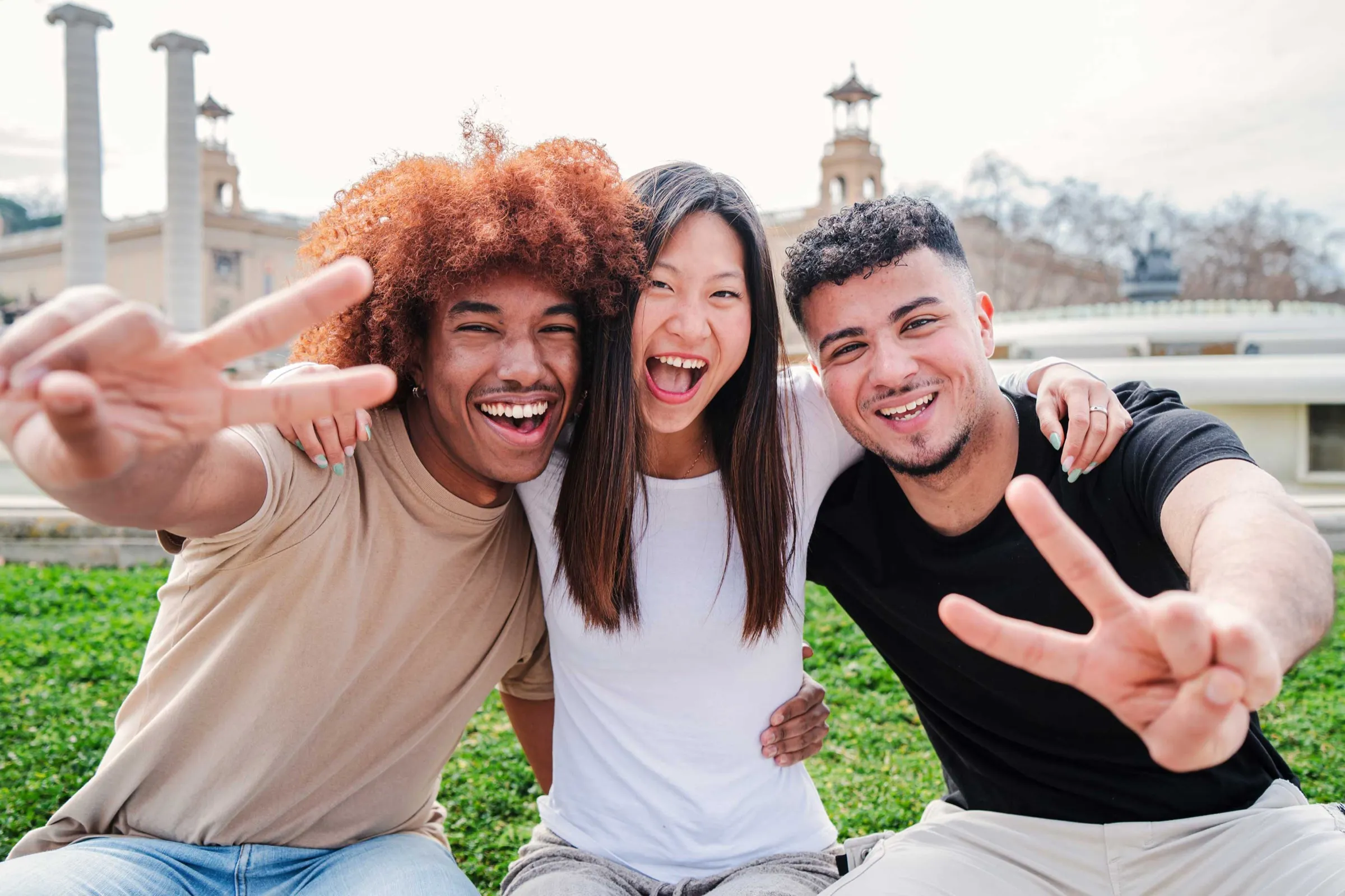 A group of smiling students making the peace sign together