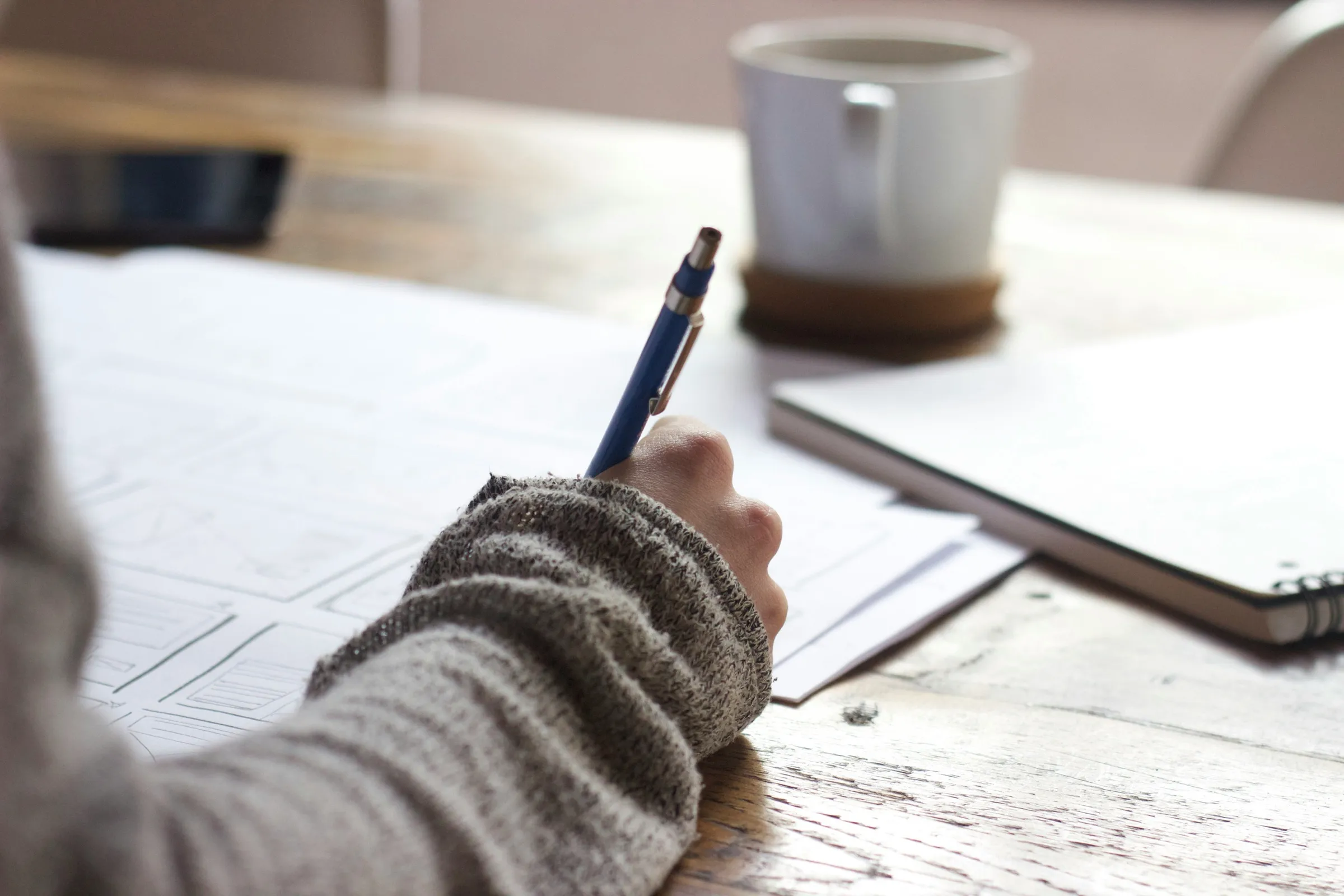 A student writing notes in a notebook at a desk